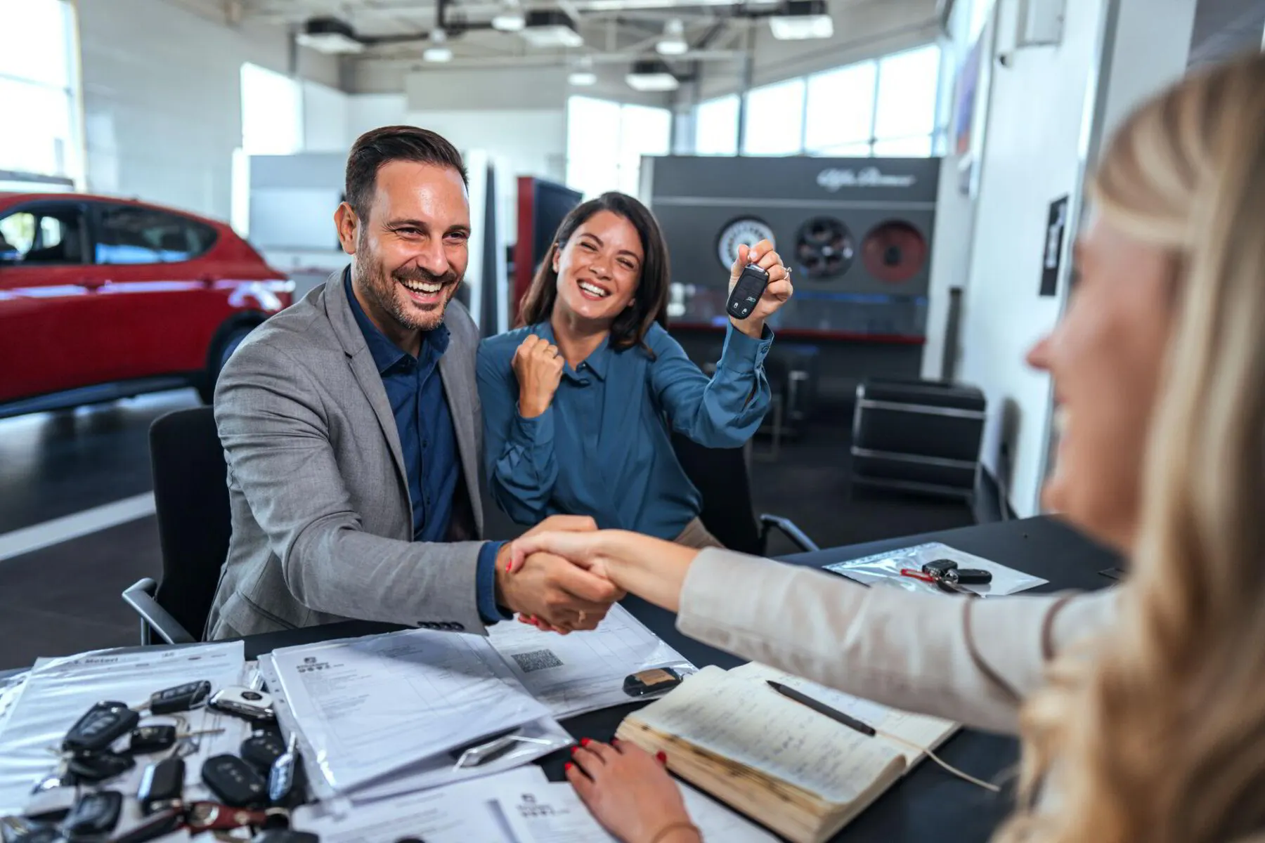 Un couple reçoit les clés de son véhicule après la signature